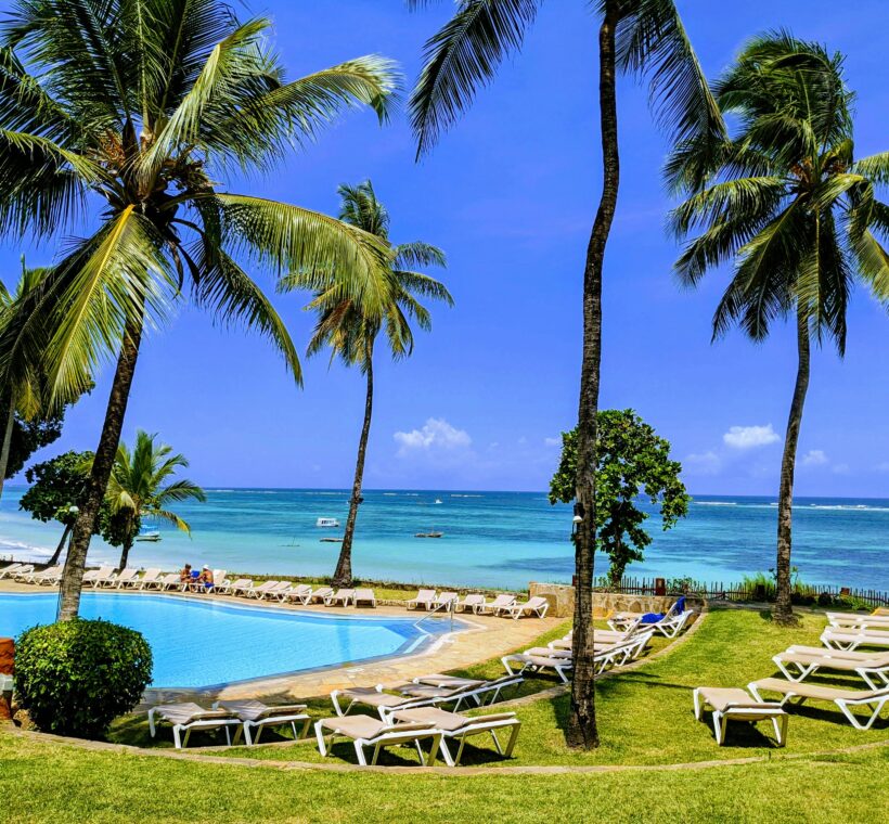 Mombasa Kenya beach resort with swimming pool, palm trees, sun loungers, and ocean view