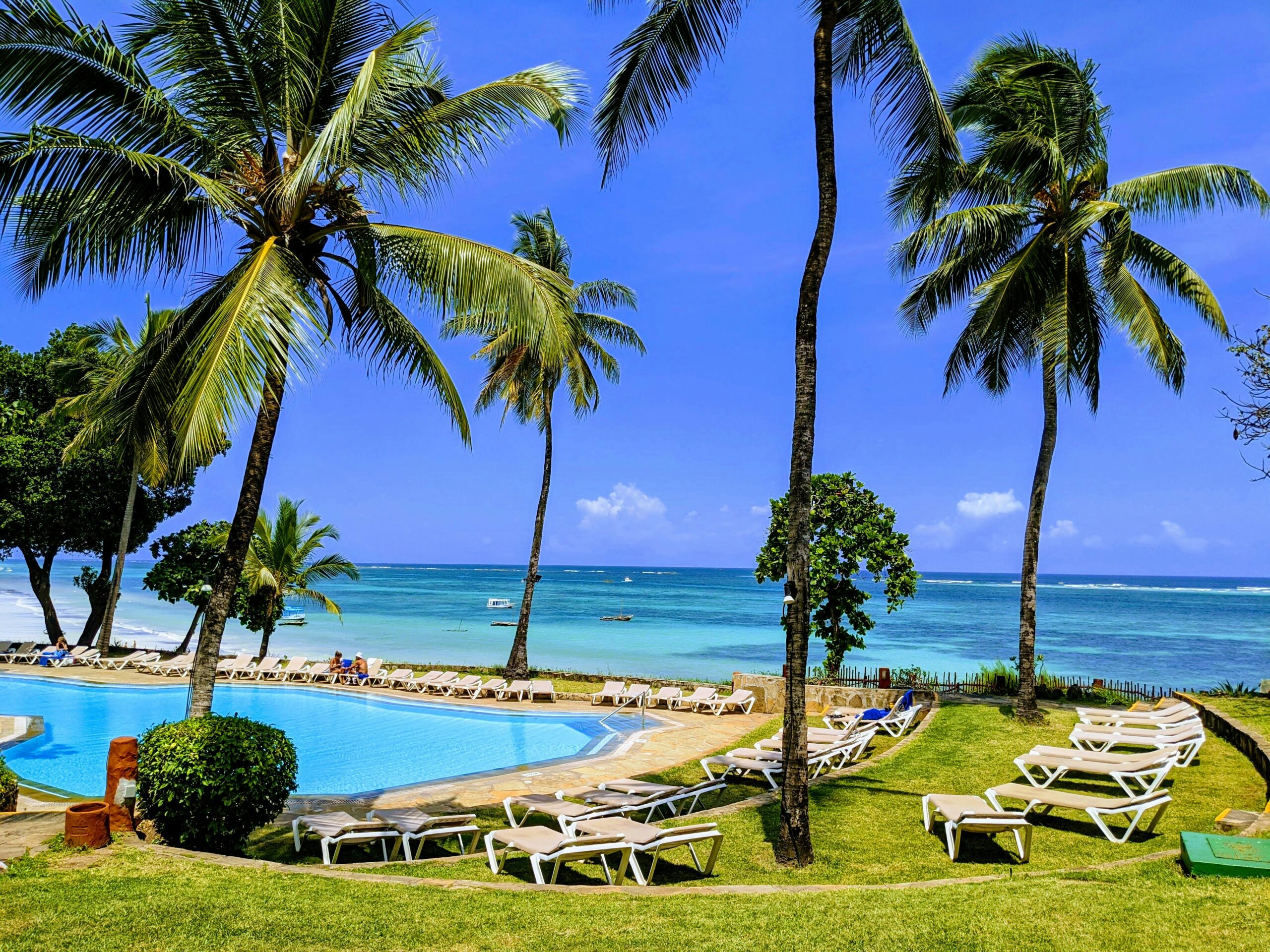 Mombasa Kenya beach resort with swimming pool, palm trees, sun loungers, and ocean view