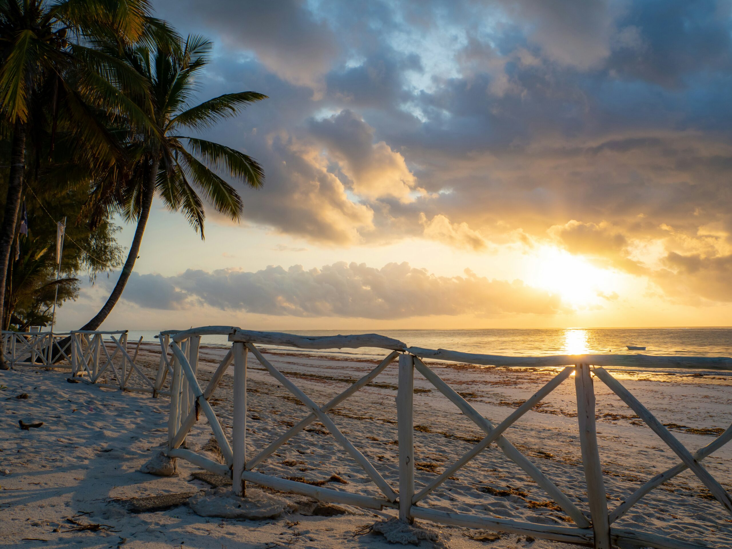 Diani Beach Kenya sunset with palm trees, white sand, and ocean view